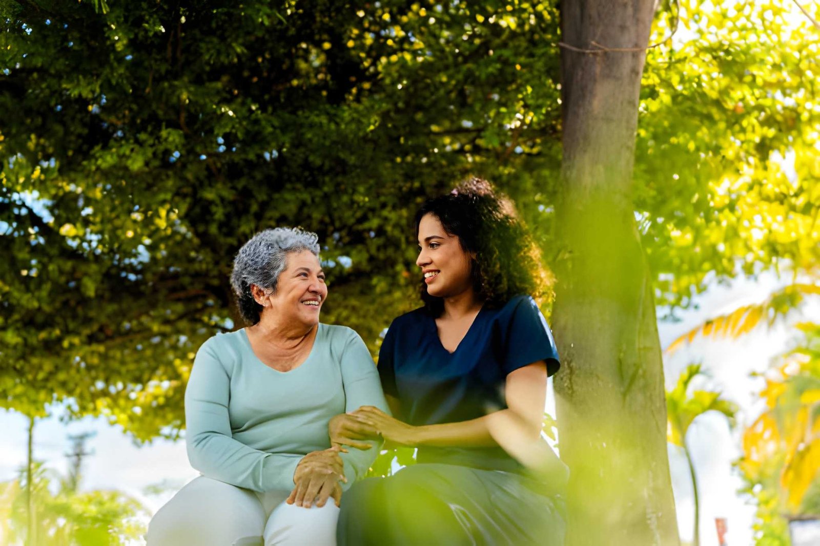 Caregiver and older adult talking together outdoors