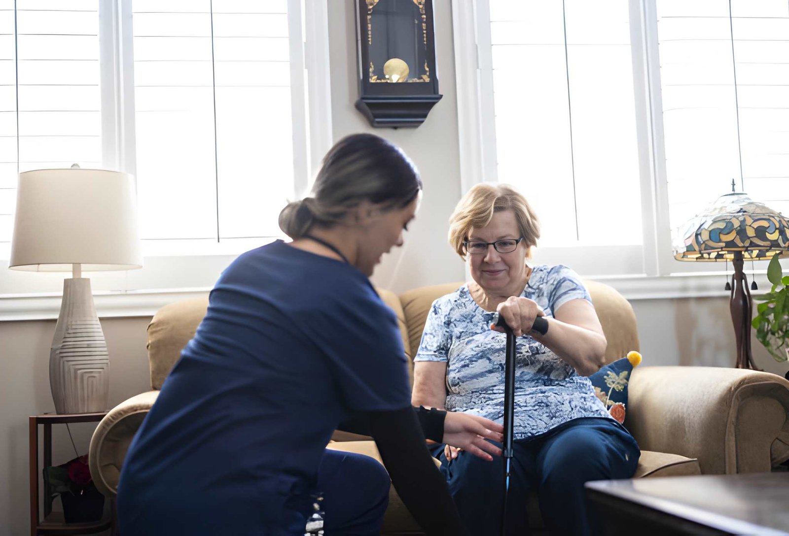 Caregiver assisting an older adult with mobility at home