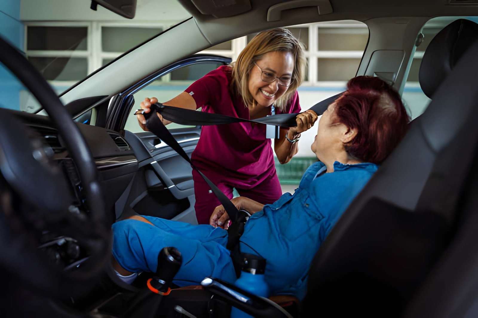 Caregiver helping an older adult enter a vehicle